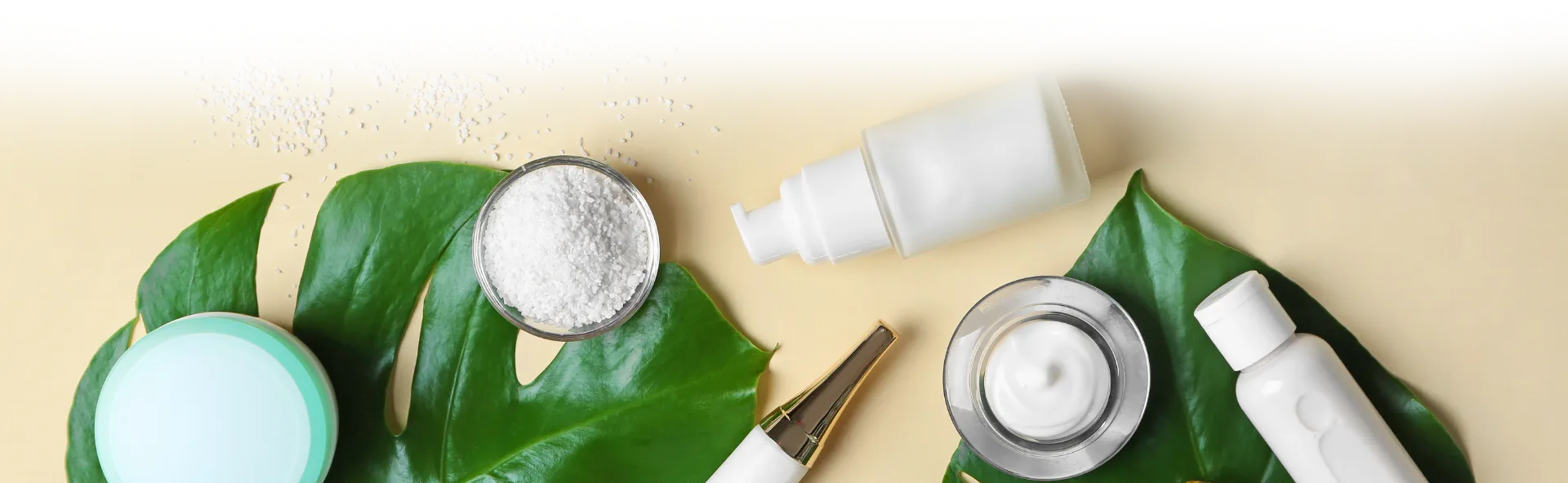 Skin care products on a table with a leaf.