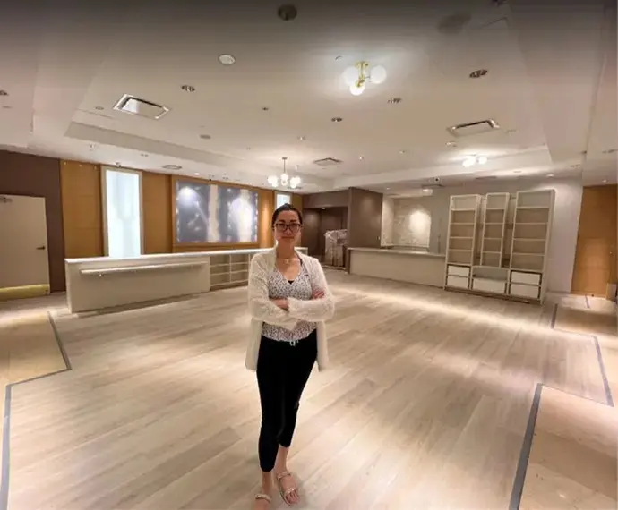 Woman standing in an empty retail space.