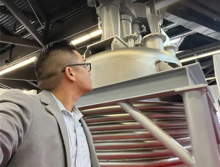 Man looking up at industrial machinery.