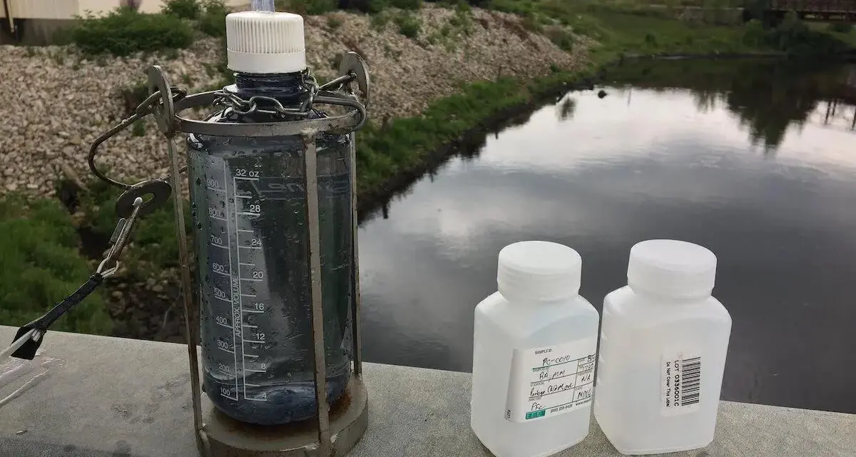 Water samples in bottles by river.